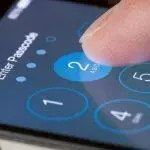 Primer plano de un dedo introduciendo un código de acceso en la pantalla de un smartphone. Se muestra 
