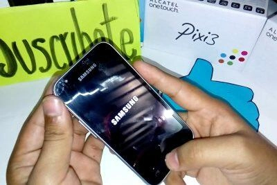 Manos sosteniendo un teléfono Samsung con el logotipo de Samsung. Desbloqueando un Samsung J1.