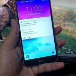 Mano sosteniendo el teléfono LG K10 bloqueado mostrando notificaciones. Desbloqueando el LG K10.